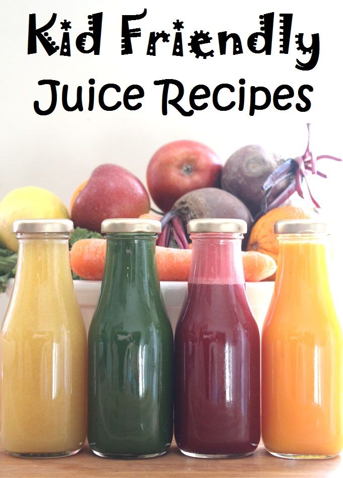 three bottles of juice sitting on top of a table next to some fruit and vegetables