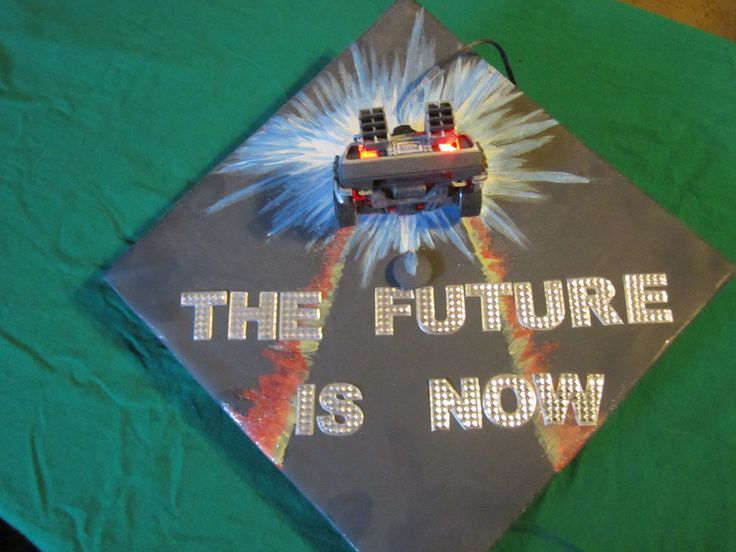 a green graduation cap with a lego car on it that says the future is now