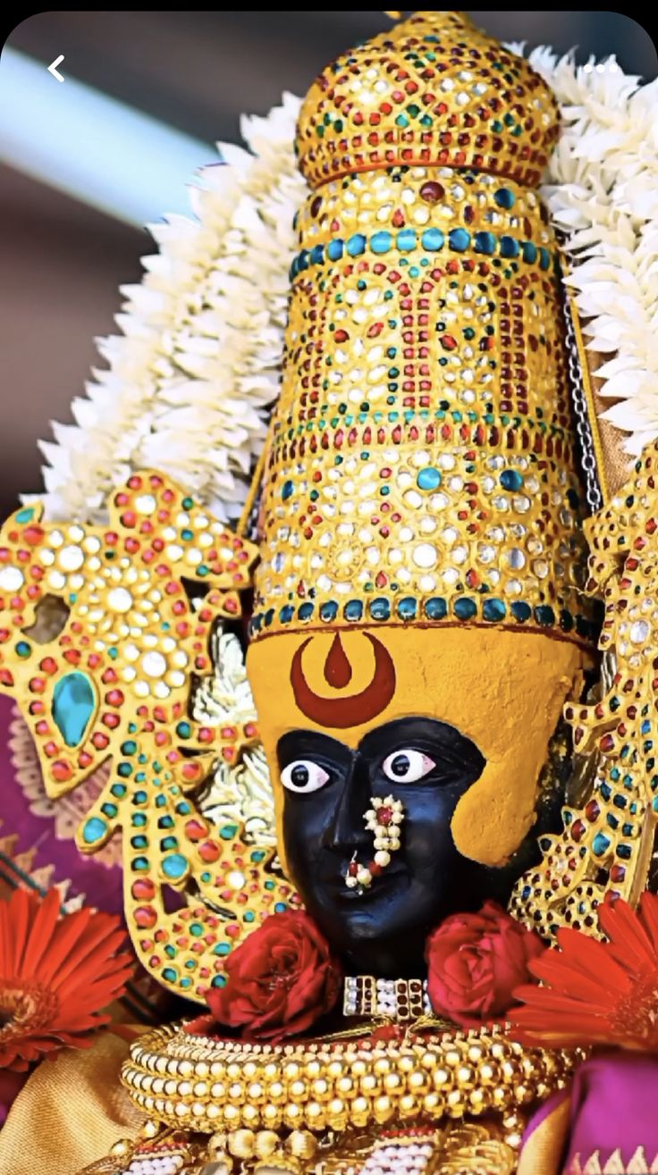 an elaborately decorated mask is displayed in front of the camera, with other decorations around it