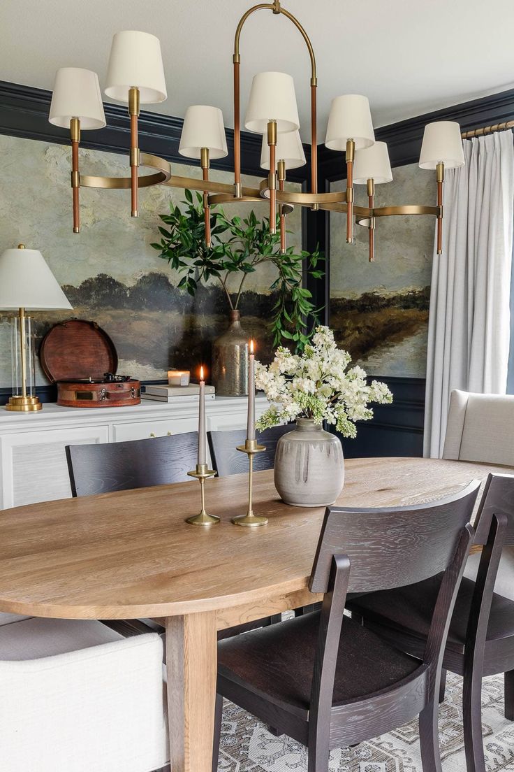 a dining room table with chairs and a vase filled with flowers on top of it