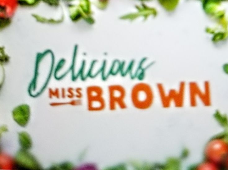 the words delicious miss brown are surrounded by green leaves and red tomatoes on a white background