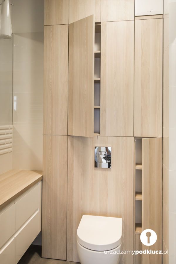 a white toilet sitting next to a wooden cabinet