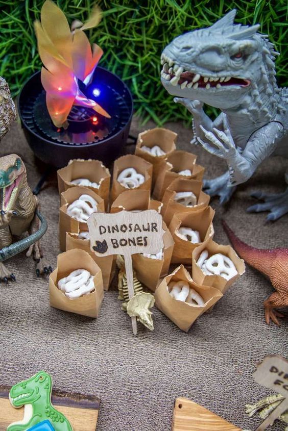 dinosaur bones are on the ground next to some fake dinosaurs and other toy items in boxes