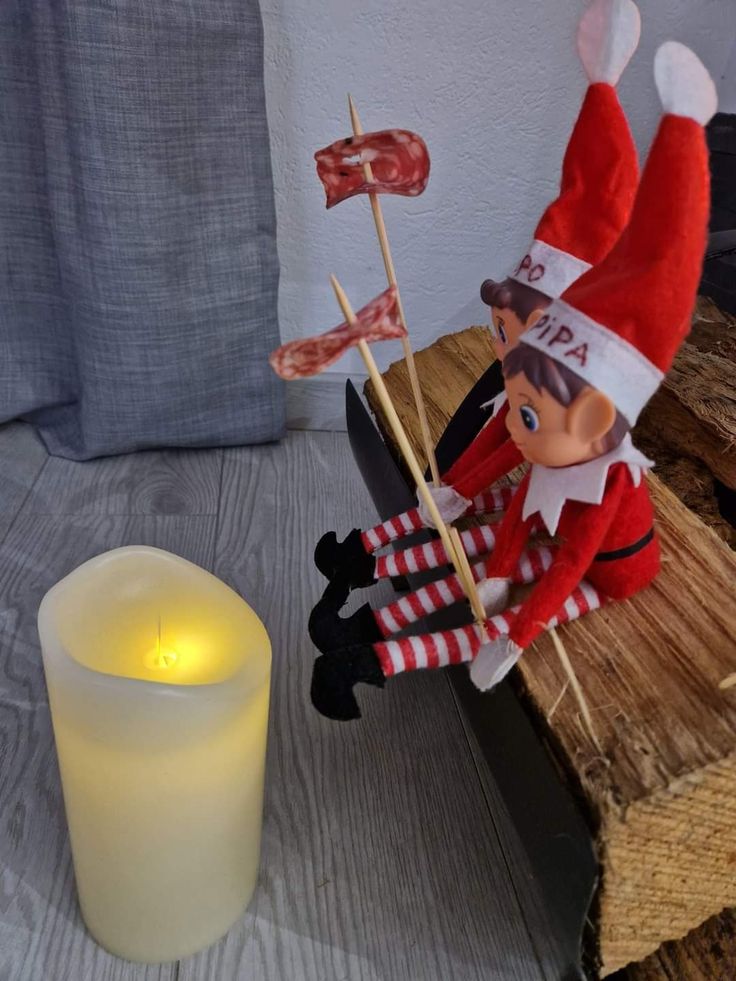 an elf is sitting on a bench next to a candle