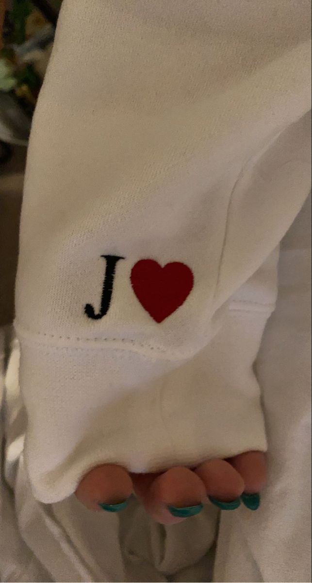 i love j embroidered on someone's white shirt