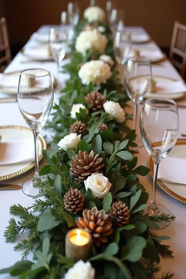 a long table with white flowers and pine cones