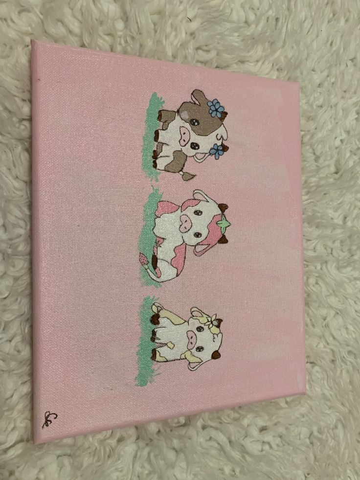 a pink canvas with three cartoon cows on it