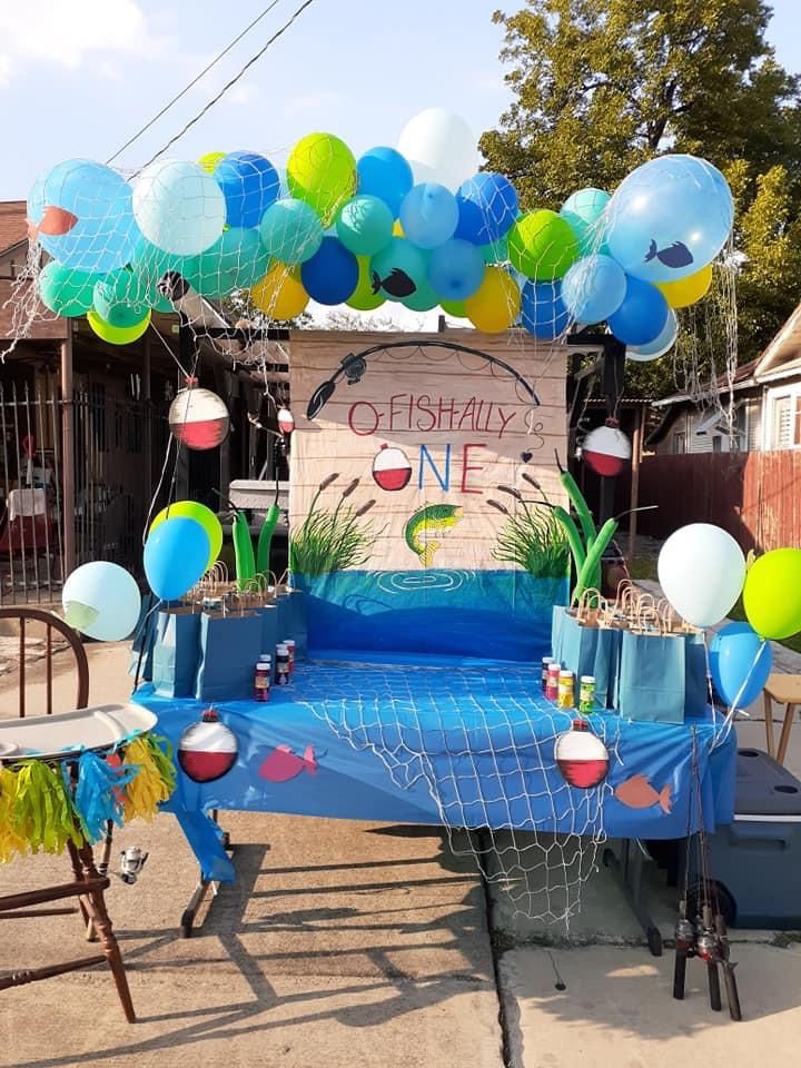 an outdoor birthday party setup with balloons, streamers and decorations on the table in front of it