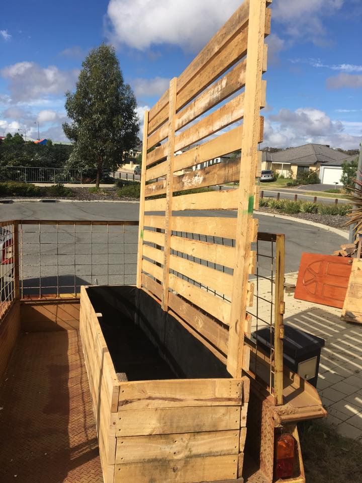 a large wooden bed sitting on top of a roof next to a street and trees