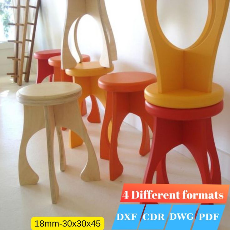 four different colored stools sitting next to each other in front of a white wall