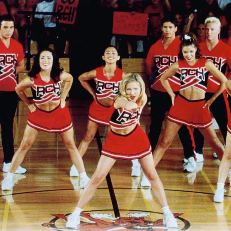 a group of women in red cheerleader outfits on a basketball court with the words bring it on