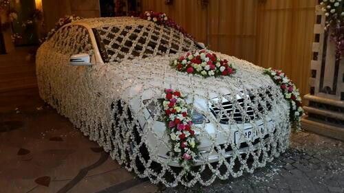 a white car covered in flowers on display