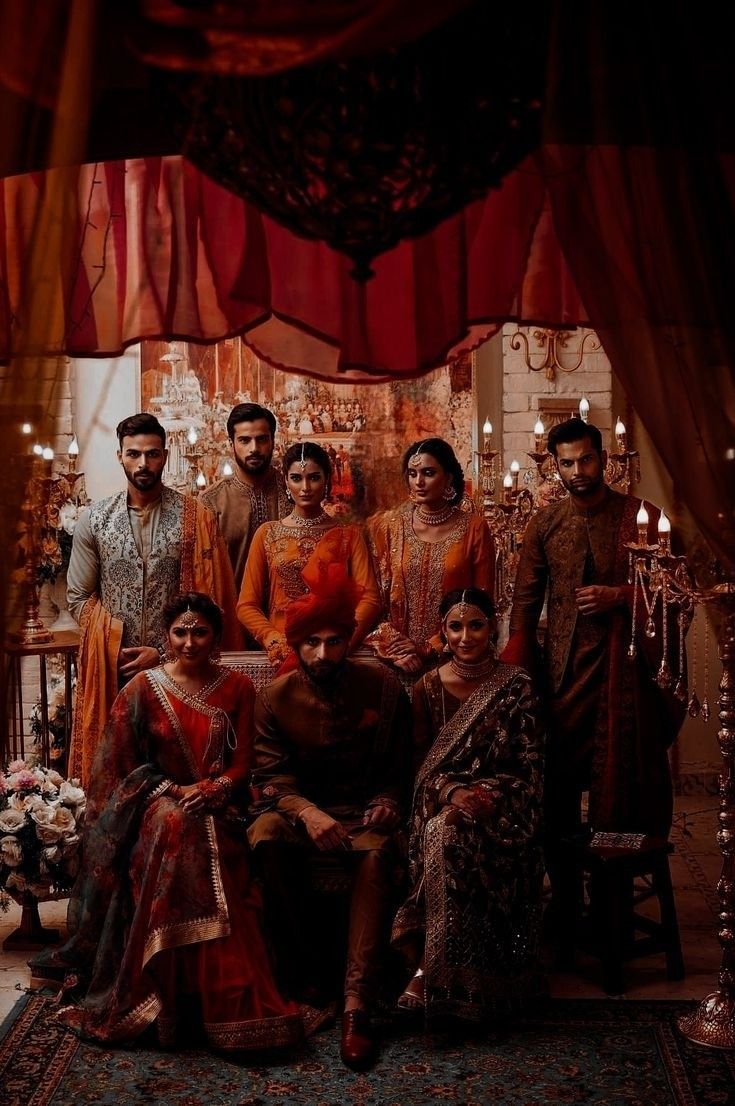 a group of people standing next to each other in front of a red and orange curtain