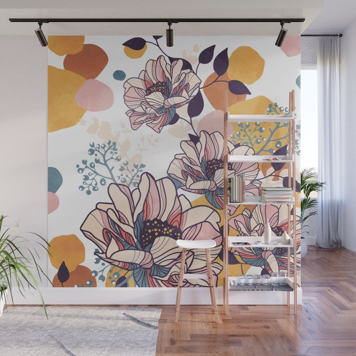 a wall mural with flowers on it in an empty room next to a chair and plant