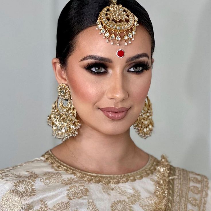 Balance glamour and tradition for a timeless look! The look includes a classic oversized maang teekah along with a pair of earrings composed of kundan accents along with moti embellishments. This look comes in two options: Earrings with Teekah Earrings without Teekah Please select the desired option at the time of purchase. Gold-plated on high-quality brass as base metal. Made by order. Kindly allow 4-6 weeks for the delivery of this item. For custom or urgent requests, please contact support@al Wedding Chandbalis With Tilla, Elegant Chandbali Tikka For Navratri, Bollywood Kundan Bridal Earrings With Zari Work, Elegant Jhumkas With Mirror Work For Navratri, Chandbali Tikka For Eid Festival, Bollywood Kundan Chandbali Sets, Bollywood Style Chandbalis With Mirror Work For Navratri, Bollywood Style Festive Chandbalis With Mirror Work, Bollywood Style Chandbalis With Mirror Work For Festive Occasions