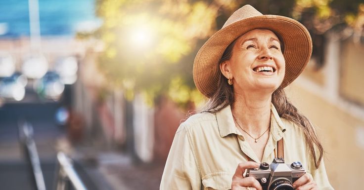 a woman wearing a hat and holding a camera