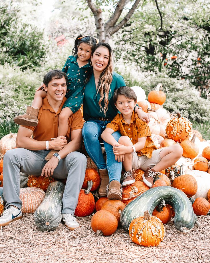 a family posing for a photo in front of pumpkins