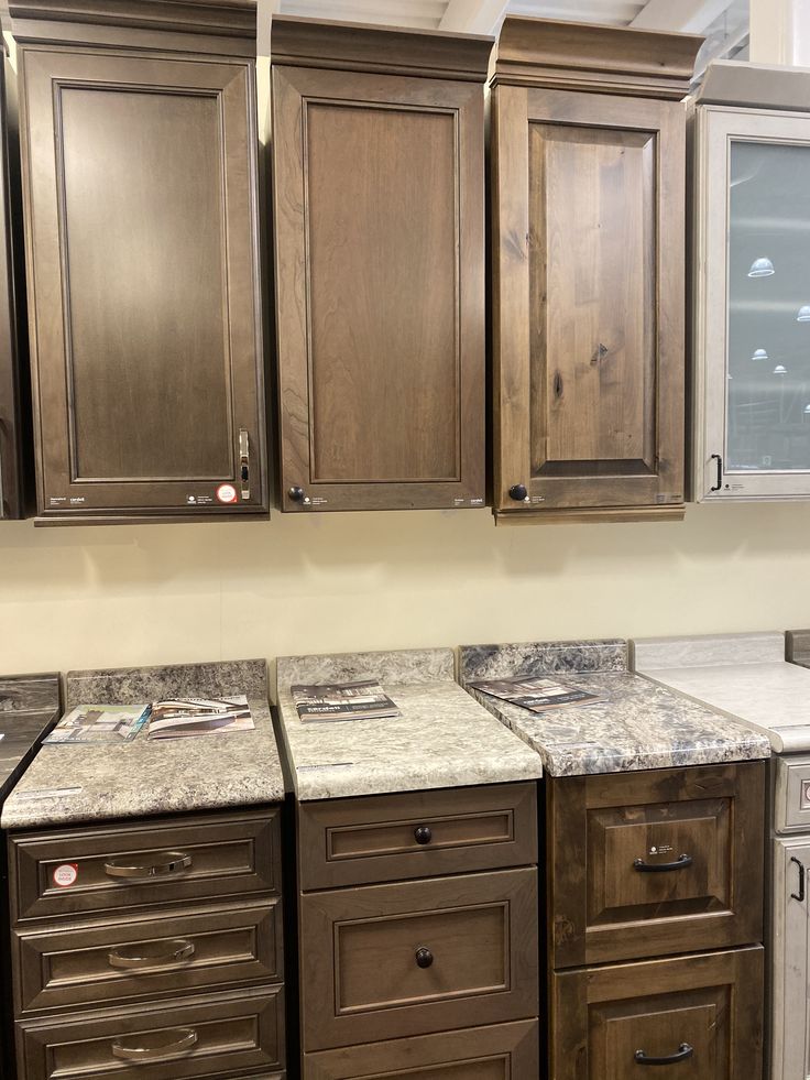 a kitchen with wooden cabinets and marble counter tops