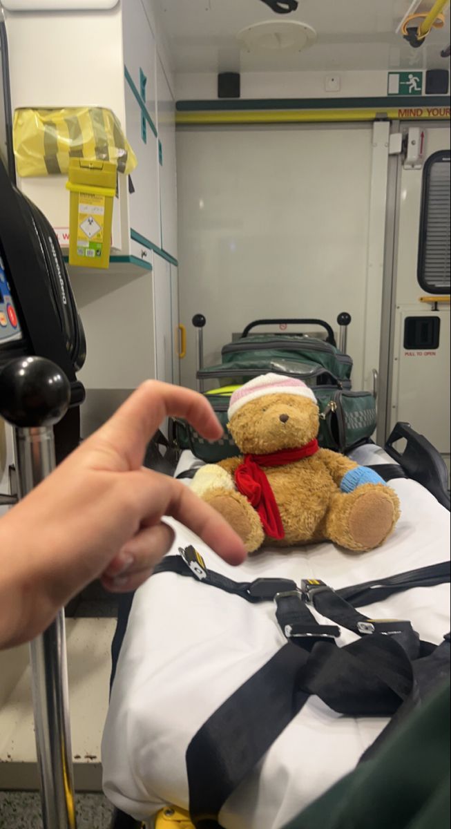 a teddy bear sitting on top of a hospital bed