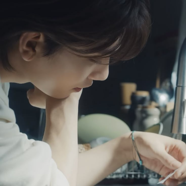 a woman is working on her laptop in the kitchen