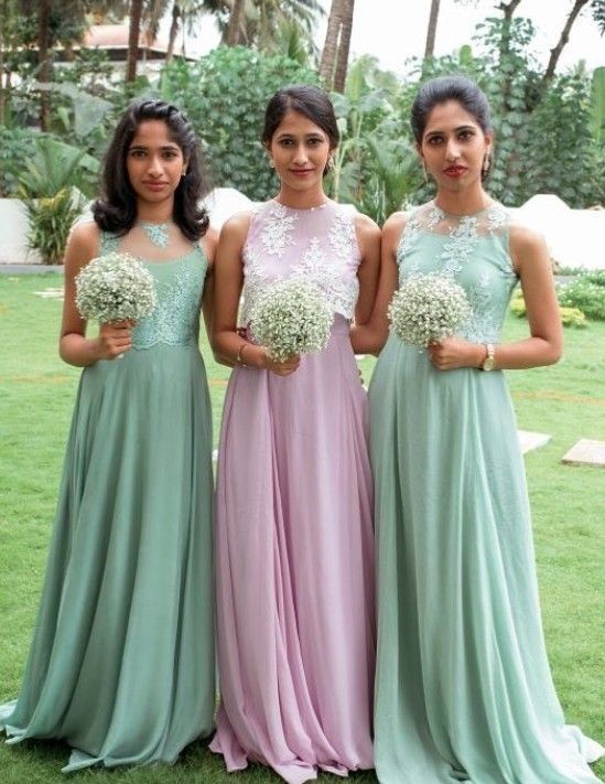 three women standing next to each other in long dresses with flowers on their chests