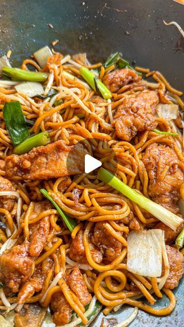 stir fried noodles with meat and vegetables in a wok