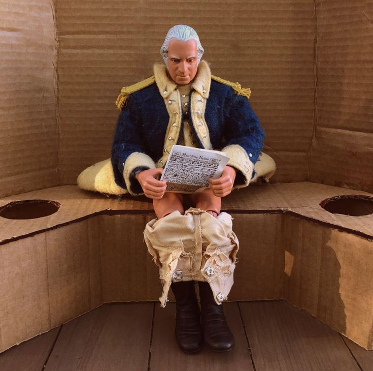 a man sitting on top of a cardboard box