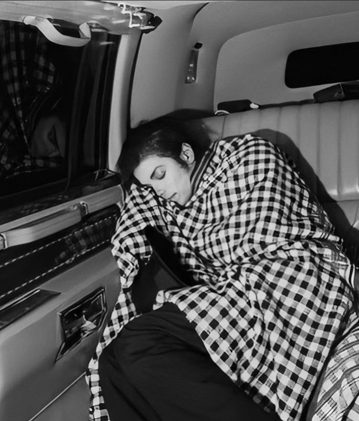 a woman sleeping in the back of a car