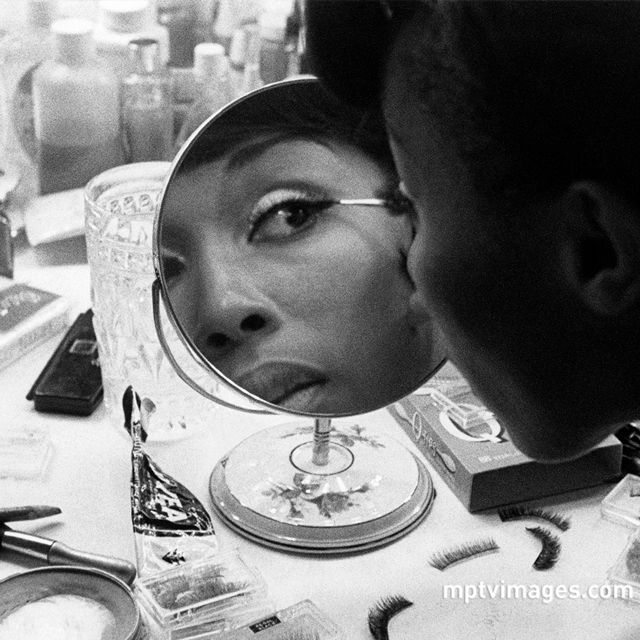 a woman looking at her reflection in the mirror