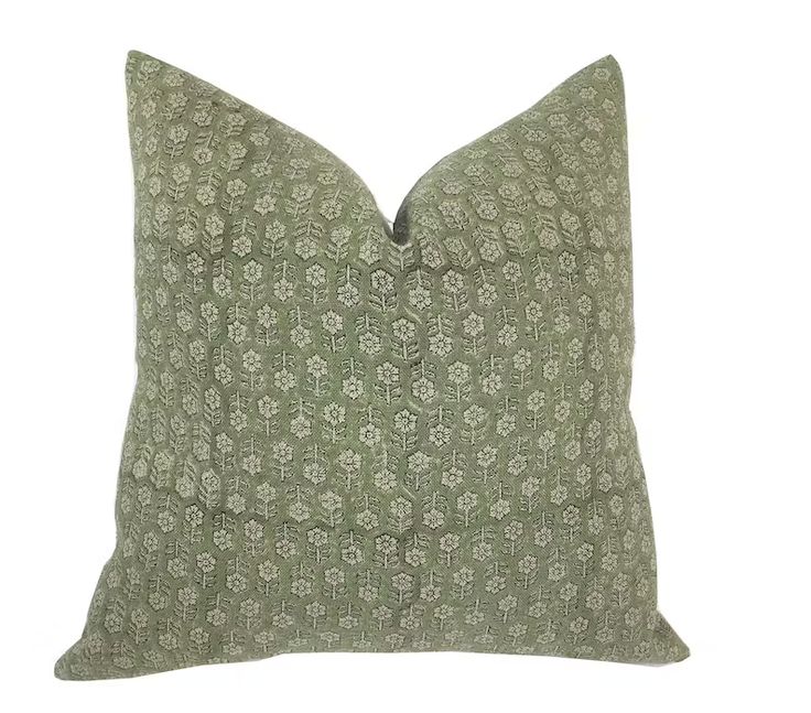 a green and white pillow on a white background