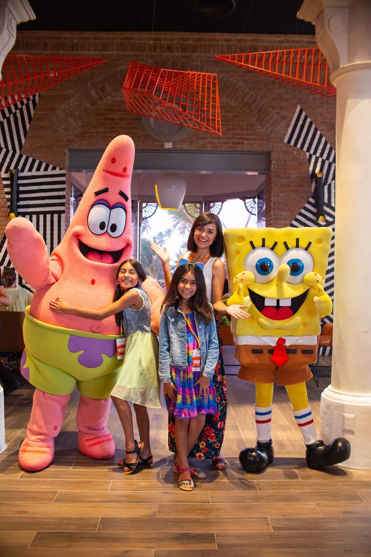 three girls standing next to spongebob characters