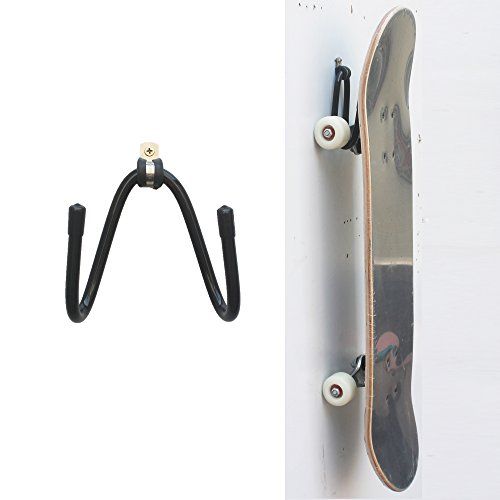 a skateboard is hanging on the wall next to a pair of black hooks and a white door