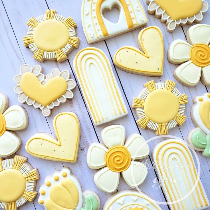 decorated cookies are arranged on a table with flowers, hearts and other decorative items in the shape of letters