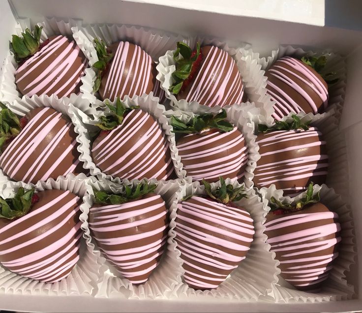 chocolate covered strawberries in a white box with green leaves on the top and bottom