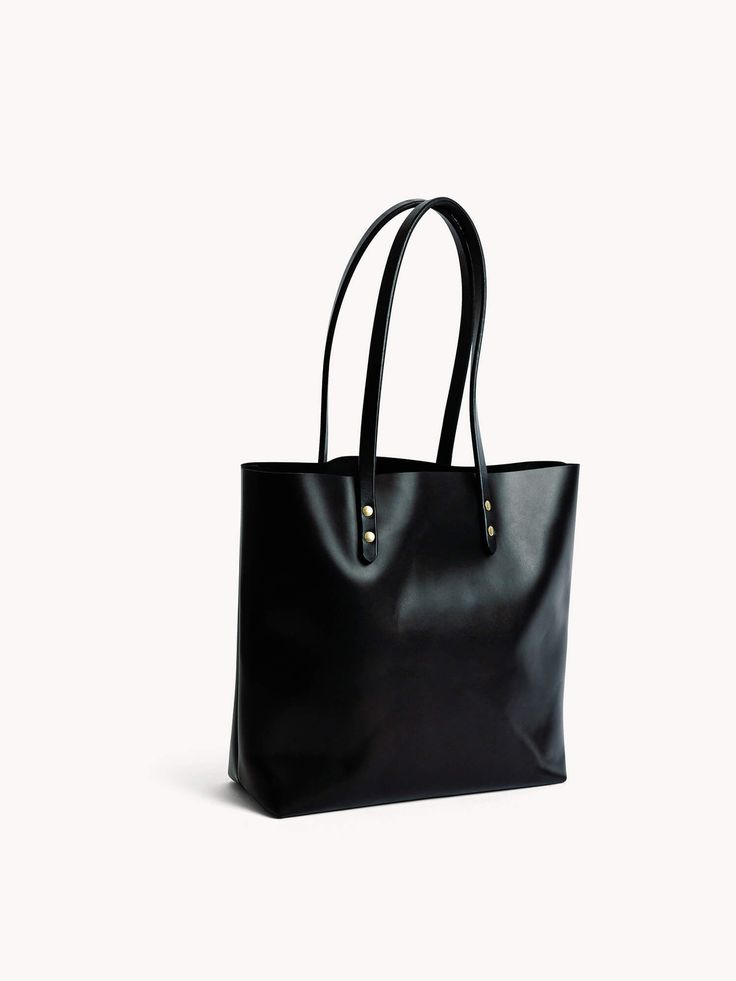 The Medium Tote takes inspiration from our best-selling Large Classic Tote. With a mirrored design, this smaller version shares similar craftsmanship, simplicity, and soft lines, making it the perfect on-the-go tote. The bags are meticulously handcrafted by our most skilled makers, using the smoothest leather, sturdy handles, and secured with solid brass hardware, ensuring durability that lasts a lifetime. This bag has a 9.5” shoulder drop, offering comfortable carrying wherever your day takes y Timeless Rectangular Everyday Shoulder Bag, Timeless Rectangular Shoulder Bag For Everyday, Classic Square Bucket Bag For Everyday Use, Classic Square Bucket Bag For Everyday, Timeless Smooth Grain Shoulder Bag For Shopping, Elegant Long Handle Bags For Daily Use, Minimalist Tote Bag With Smooth Grain, Minimalist Smooth Grain Tote Bag, Elegant Shoulder Bag With Long Handle For Daily Use