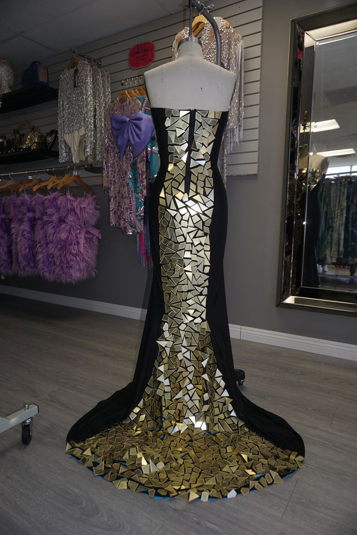 Get your shine on in this BEAUTIFUL gown! Covered in gold mirrored plates down the center of the front and back, top to bottom. Features a strapless silhouette and has good stretch. Has a train that will follow you while you walk through the room. ;) A gala, your birthday party, any occasion that you want to make a statement, this is the piece you need. Item has some stretch, but be sure to stay within your size range for the best fit. Top of dress is not a structured bustier. Embellishments are Dress With Mirror Pieces, Jumpsuit Jacket, Leggings Sale, Maxi Gowns, Bustier Top, Follow You, Crop Top Blouse, Shine On, Good Stretches