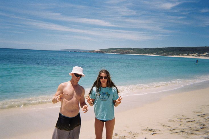 a man and woman standing on the beach