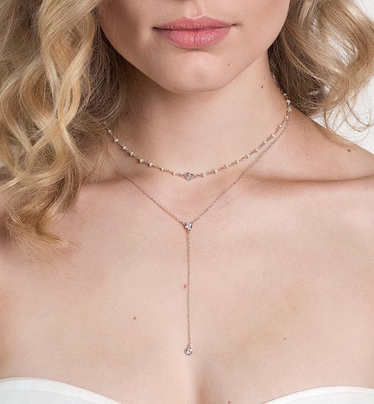 Pave-encircled cubic zirconia crystals adorn this stunning minimal lariat necklace. Lightweight design makes this piece comfortable to wear all day and night. Style with a strapless, off the shoulder, or sweetheart neckline gown for a fashion-forward bridal look. Rose Gold Vermeil 4mm Cubic Zirconia pave crystal Hypoallergenic, lead, and nickel free Chain Length: 16in (40.6cm) + Extension: 2in (5.1cm) Drop Height: 3in (7.6cm) #N321 Elegant Cubic Zirconia Backdrop Necklace With Delicate Chain, Elegant Lariat Choker Necklace For Party, Elegant Adjustable Choker Jewelry, Elegant Party Lariat Choker Necklace, Elegant Rose Gold Lariat Necklace With Clavicle Chain, Delicate Rose Gold Lariat Necklace With Clavicle Chain, Formal Backdrop Necklace With Clavicle Chain, Adjustable Delicate Backdrop Necklace For Party, Party Lariat Necklace With Adjustable Cubic Zirconia Chain