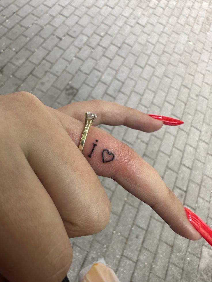 a woman's hand with the word i love on it and a small heart tattoo