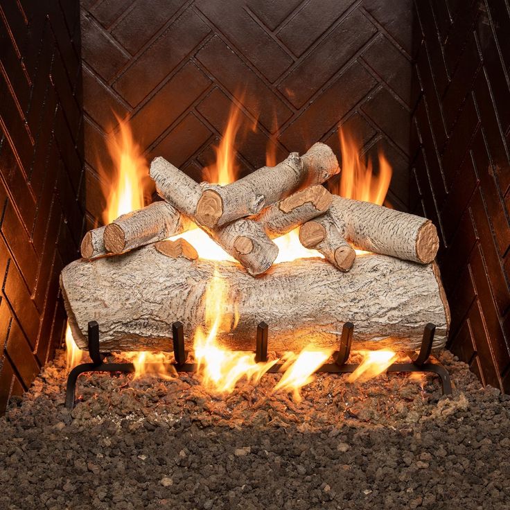 logs are stacked on top of each other in front of a fire