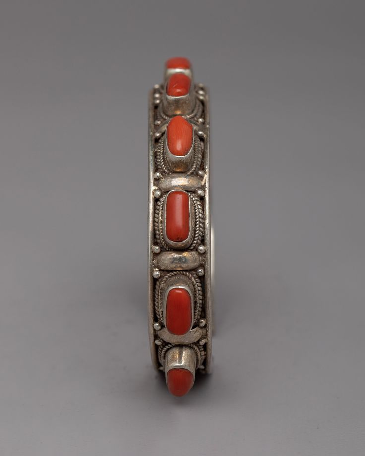 Tibetan Buddhist Bracelet About The Bracelet: Introducing the exquisite Tibetan Buddhist Bracelet, meticulously handcrafted with precision and care. Each bracelet is skillfully made using a high-quality silver alloy, ensuring durability and beauty. The centerpiece of this remarkable piece is the vibrant red coral stones that are thoughtfully embedded, adding a touch of elegance and spiritual significance. The combination of the silver alloy and the vivid red coral creates a harmonious blend of c Adjustable Artisan Red Cuff Bracelet, Adjustable Red Artisan Cuff Bracelet, Artisan Red Adjustable Cuff Bracelet, Red Adjustable Cuff Bracelet For Wedding, Adjustable Red Cuff Bracelet For Wedding, Red Sterling Silver Bangle Cuff Bracelet, Handmade Red Sterling Silver Cuff Bracelet, Traditional Red Cuff Bracelet As Gift, Adjustable Red Sterling Silver Cuff Bracelet