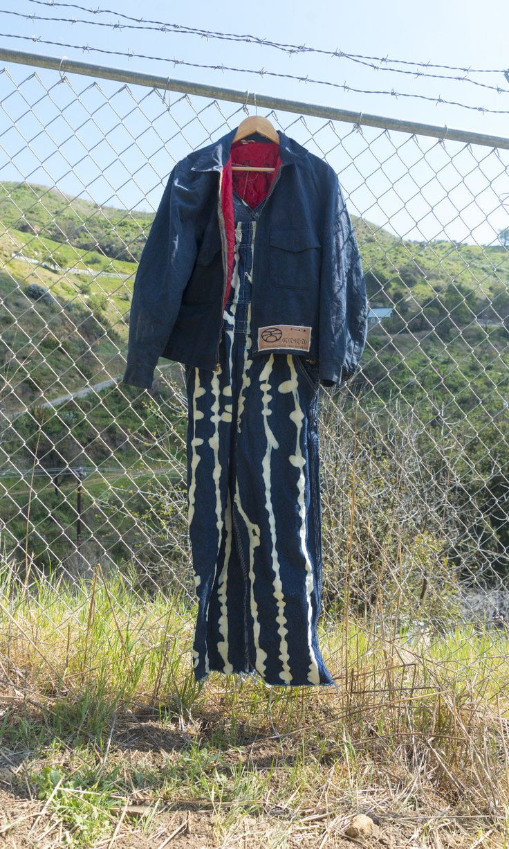 an old coat hanging on a chain link fence