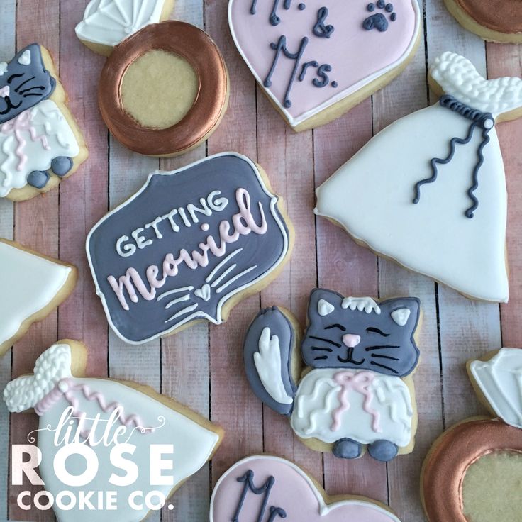 decorated cookies are arranged on a table with the words getting married written in white and pink