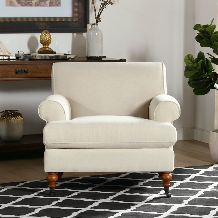 a white chair sitting on top of a black and white rug in a living room