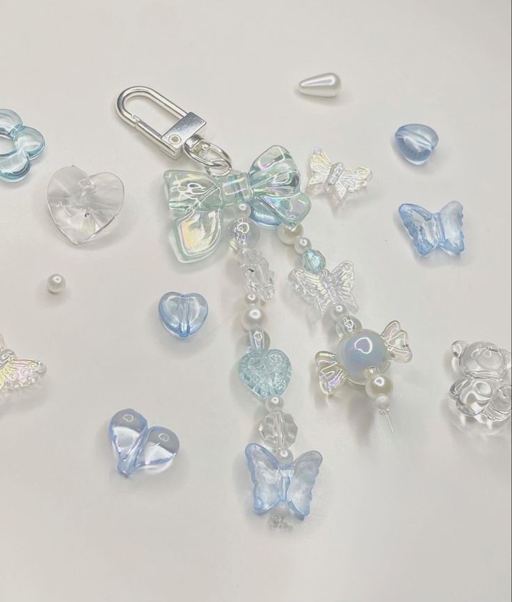 some glass beads and charms on a white surface