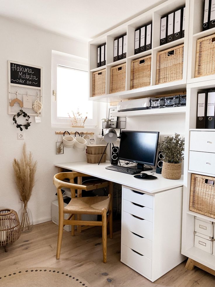 a desk with a computer on top of it in front of some baskets and other items