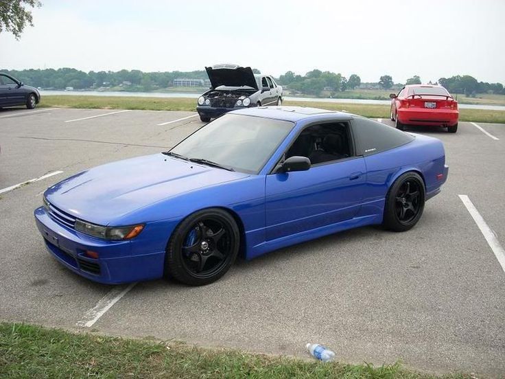 a blue car parked in a parking lot next to other cars