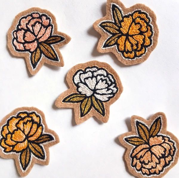 four embroidered patches with flowers on them sitting next to each other in front of a white background