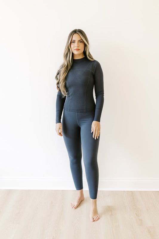 Your workout wardrobe needs this incredible top! It wicks away sweat, features a curve-skimming silhouette, and has a functional front zipper that makes it perfect for long runs on chilly days. Pair with our Active Scrunch Butt Leggings for a seriously flattering duo. FIT: Runs small - we recommend sizing up 1-2 sizes. MODEL: Mackenzie is 5’7” / 130lbs / wearing a medium. GARMENT DETAILS: ﻿Long sleeved top with exposed ribbed seams and figure-hugging profile. Midweight Long Sleeve Activewear For Workout, Fitted Half-zip Activewear For Outdoor Activities, Stretch Activewear With Thumbholes For Layering, Gray Layered Athleisure Activewear, Functional Stretch High Neck Activewear, Compressive Fall Activewear With Thumbholes, High Neck Athleisure Activewear For Gym, Fall Compressive Activewear With Thumbholes, Winter Athleisure Half-zip Activewear