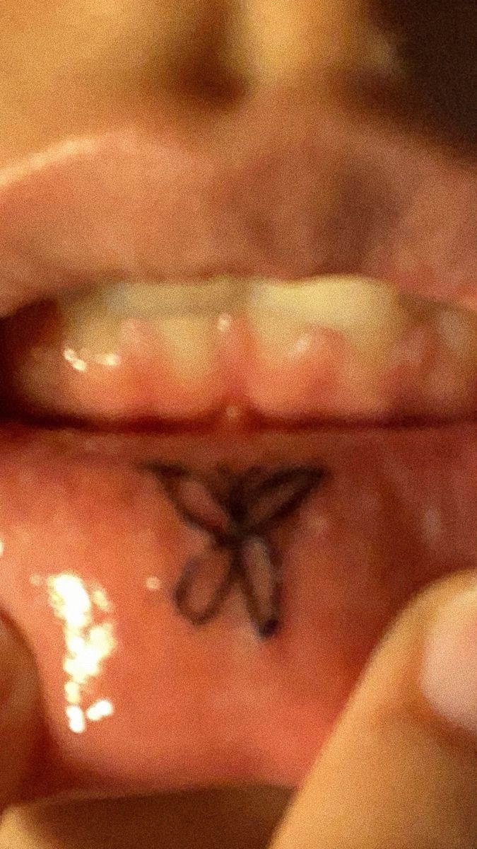 a person with a butterfly tattoo on their lip